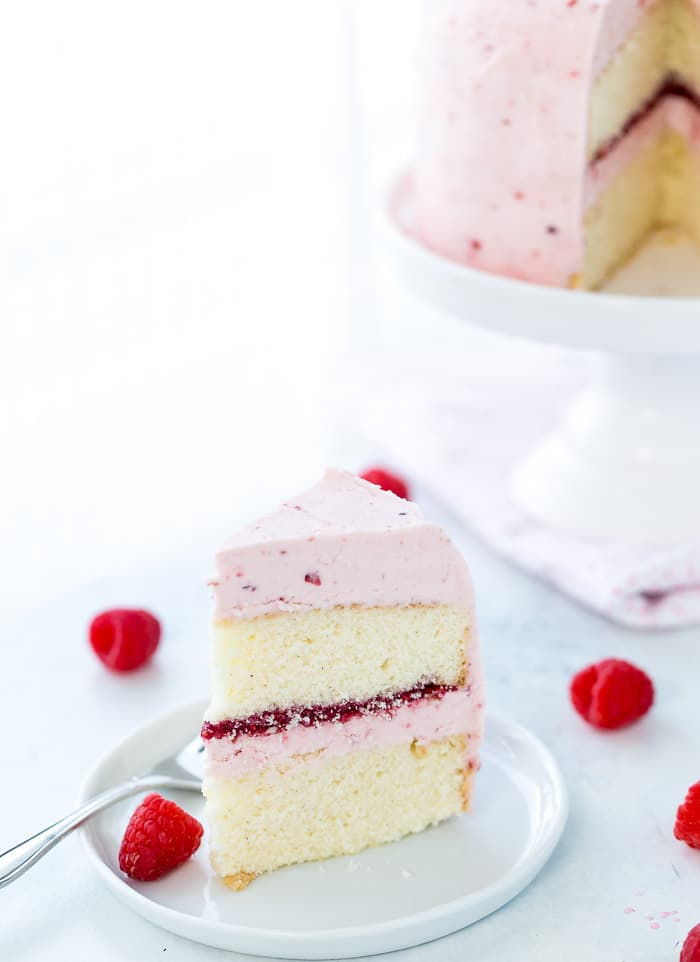 A classic Vanilla Bean Raspberry Layer Cake with moist vanilla bean cake with a sweet raspberry filling and a fluffy whipped vanilla bean frosting!