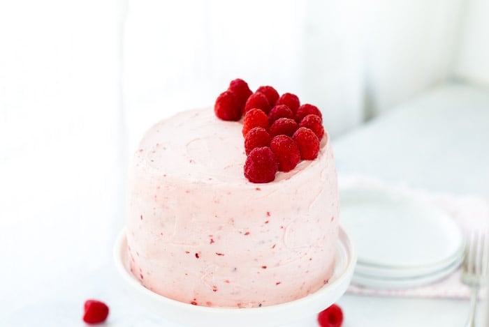 A classic Vanilla Bean Raspberry Layer Cake with moist vanilla bean cake with a sweet raspberry filling and a fluffy whipped vanilla bean frosting!