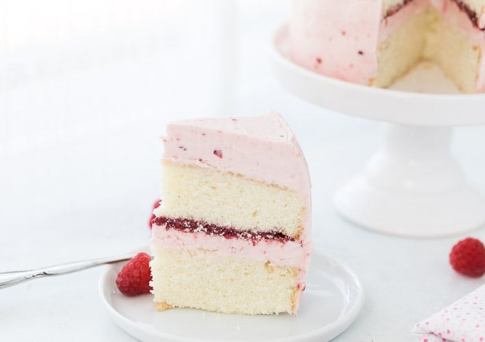 A classic Vanilla Bean Raspberry Layer Cake with moist vanilla bean cake with a sweet raspberry filling and a fluffy whipped vanilla bean frosting!