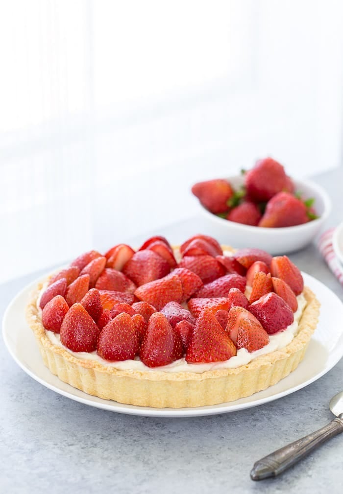 This strawberry mascarpone tart is a beautiful 3-layered tart with a buttery crust and a creamy lemon mascarpone filling topped with fresh strawberries.