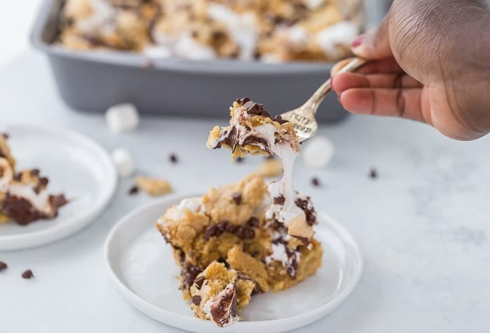 These classic s'mores cookie bars are ooey-gooey perfection with a graham cracker cookie dough crust filled with marshmallow fluff and chocolate squares.