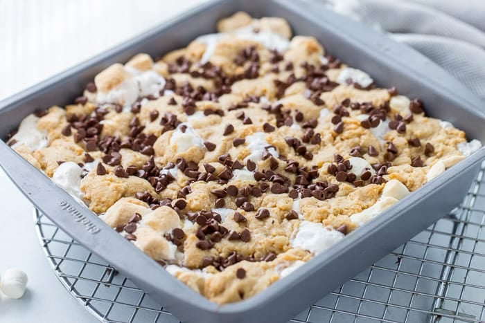 These classic s'mores cookie bars are ooey-gooey perfection with a graham cracker cookie dough crust filled with marshmallow fluff and chocolate squares.