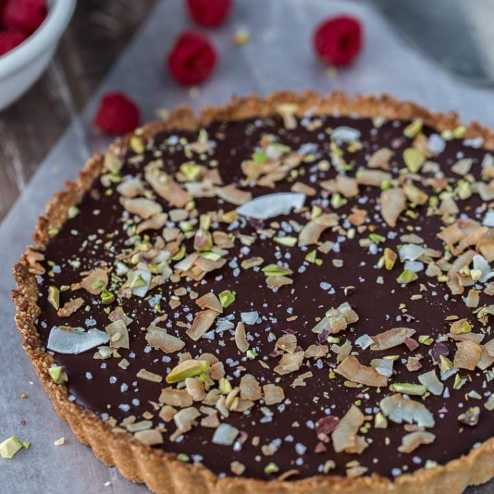 A decadent gluten free and vegan chocolate coconut tart that starts with a chewy coconut almond crust and is filled with creamy chocolate coconut ganache.