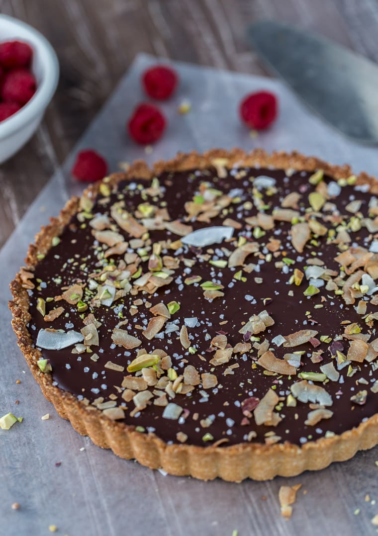 A decadent gluten free and vegan chocolate coconut tart that starts with a chewy coconut almond crust and is filled with creamy chocolate coconut ganache.