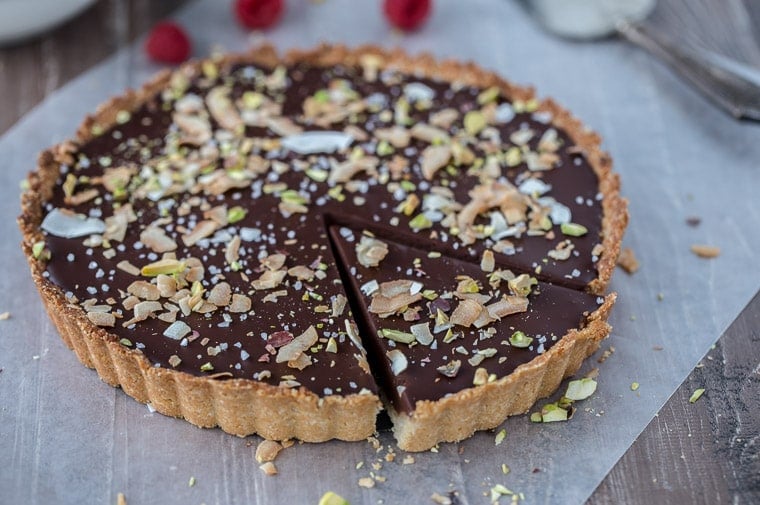 A decadent gluten free and vegan chocolate coconut tart that starts with a chewy coconut almond crust and is filled with creamy chocolate coconut ganache.