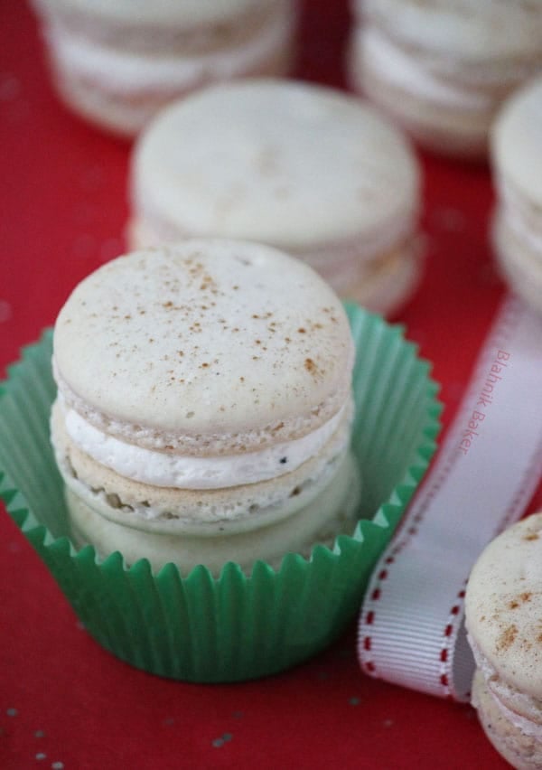 Eggnog macarons are perfectly spiced holiday cookies, with hints of cinnamon, cloves and nutmeg, filled with creamy eggnog buttercream. | Recipe on BlahnikBaker.com