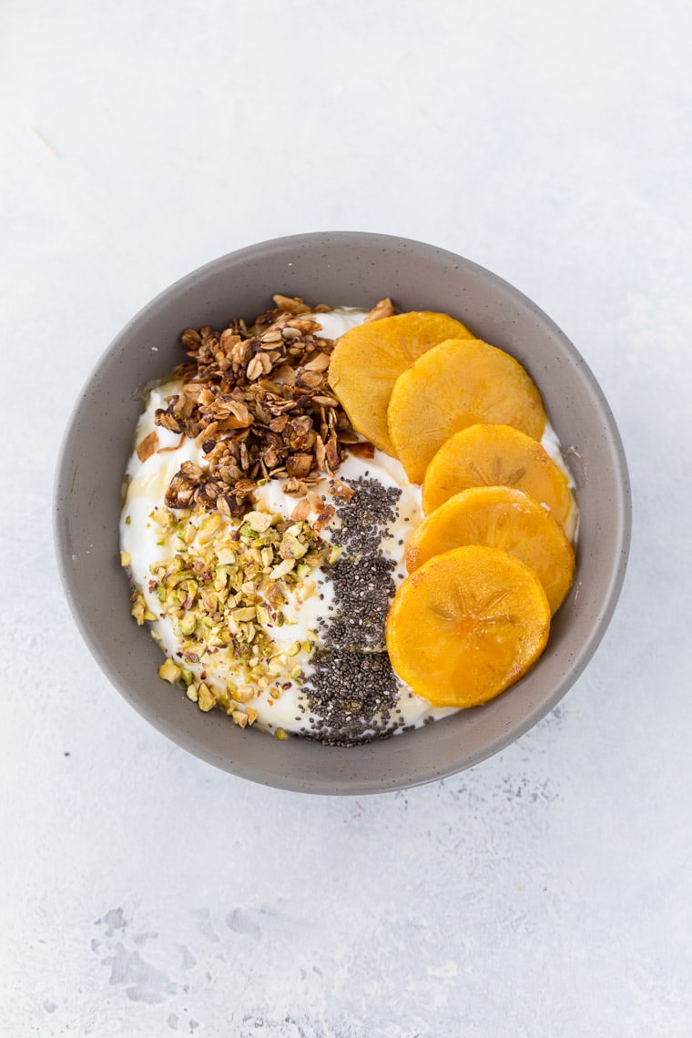 This roasted persimmon yogurt bowl is a quick and easy breakfast bowl full of winter flavors. 