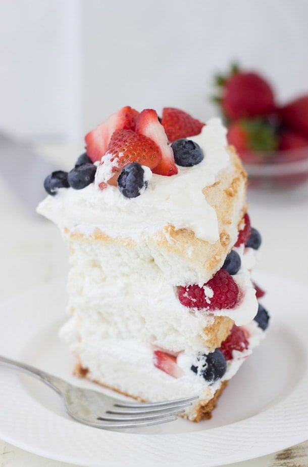 This classic angel food cake recipe is filled with homemade dairy-free coconut whipped cream and studded with berries for a pretty 4th of July look!