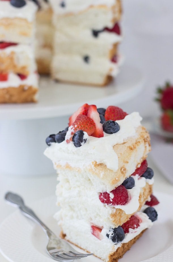 This classic angel food cake recipe is filled with homemade dairy-free coconut whipped cream and studded with berries for a pretty 4th of July look!