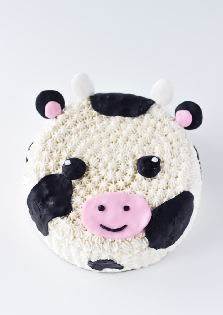 This Cow Cake tutorial makes for an easy and adorable fondant and frosting decorated cow cake; perfect for any cow-themed celebration. Get the recipe on BlahnikBaker.com