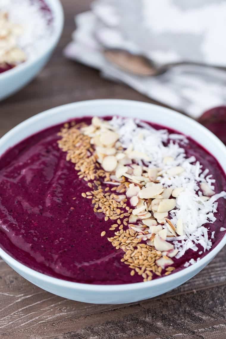 A healthy berry beets smoothie bowl with mint, chia seeds and coconut.