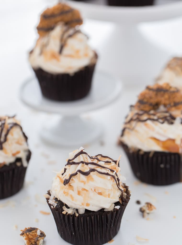 These Samoa cupcakes start with chocolate coconut cupcakes with caramel coconut frosting garnished with coconut flakes and chocolate drizzles.