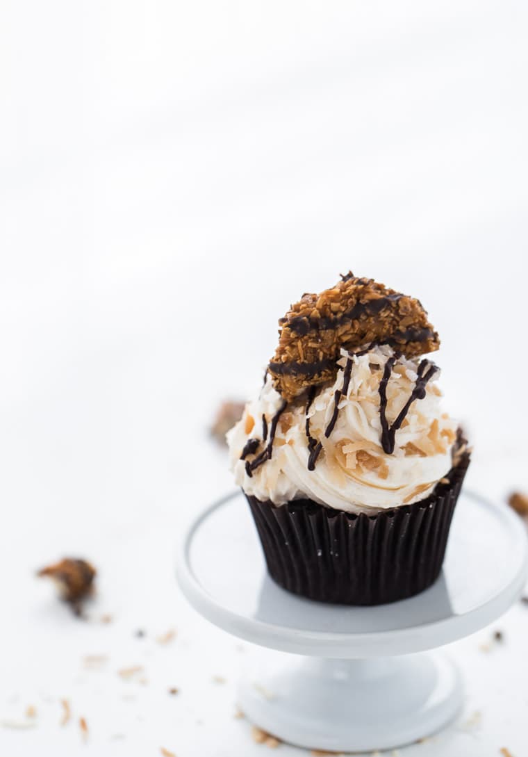 These Samoa cupcakes start with chocolate coconut cupcakes with caramel coconut frosting garnished with coconut flakes and chocolate drizzles.