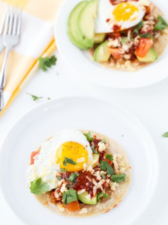 An authentic huevos rancheros recipe with homemade red chile paste, fried eggs and refried beans.