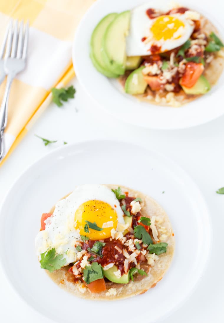 An authentic huevos rancheros recipe with homemade red chile paste, fried eggs and refried beans. 