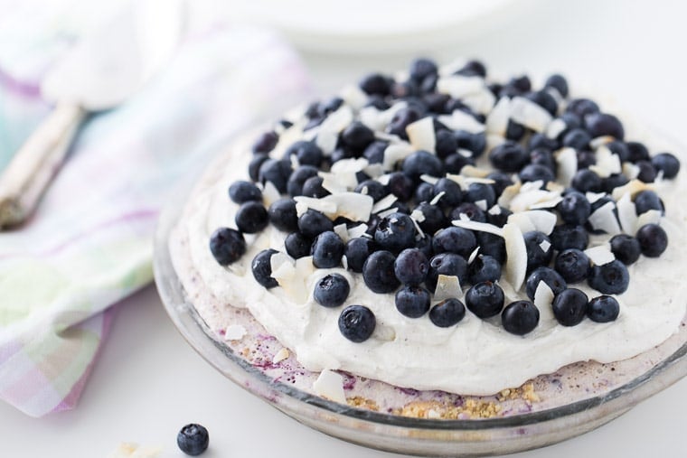 This Blueberry Coconut Ice Cream Pie is a no-bake recipe with a crunchy almond gluten free crust and is filled with coconut ice cream and blueberry sauce. 