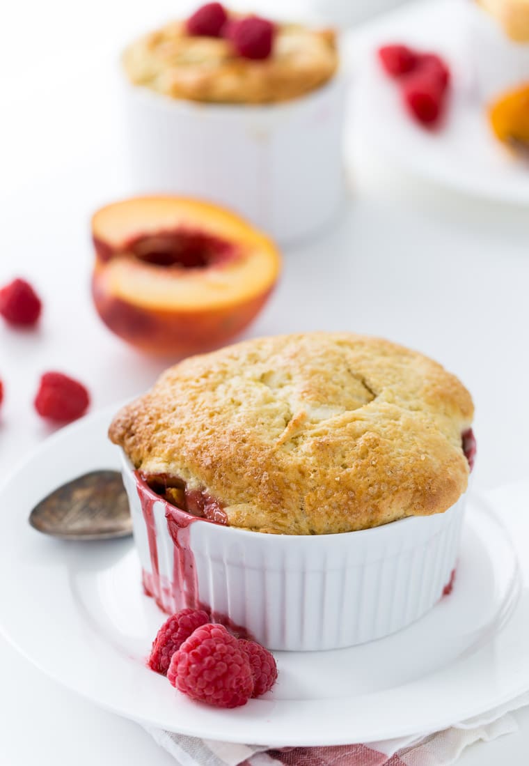 A delicious homemade peach raspberry cobbler recipe with a juicy peach filling and a moist and flaky biscuit topping