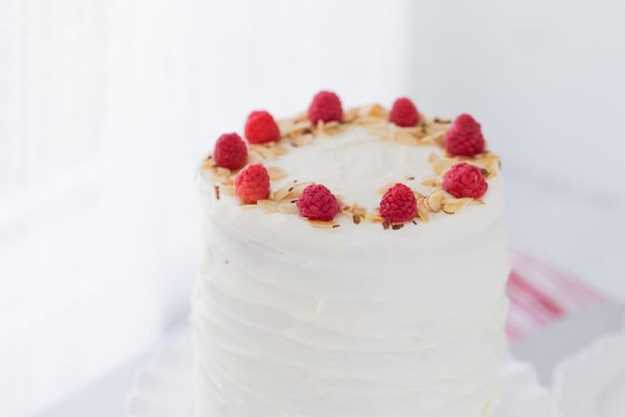 A luscious lemon raspberry cake recipe that is filled with a whipped honey mascarpone filling, raspberry compote and sweet cream cheese frosting.