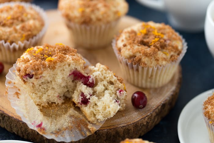 Eggnog Cinnamon Swirl Muffins with one muffin cut in half on a wooden plank.