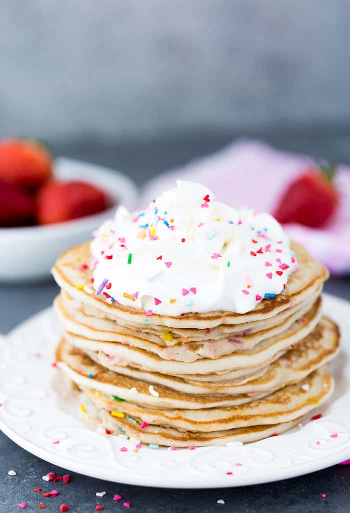 A stack of Funfetti pancakes on a white plate.