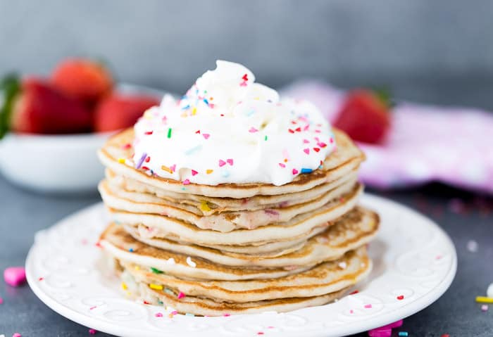 A stack of Funfetti pancakes on a white plate.