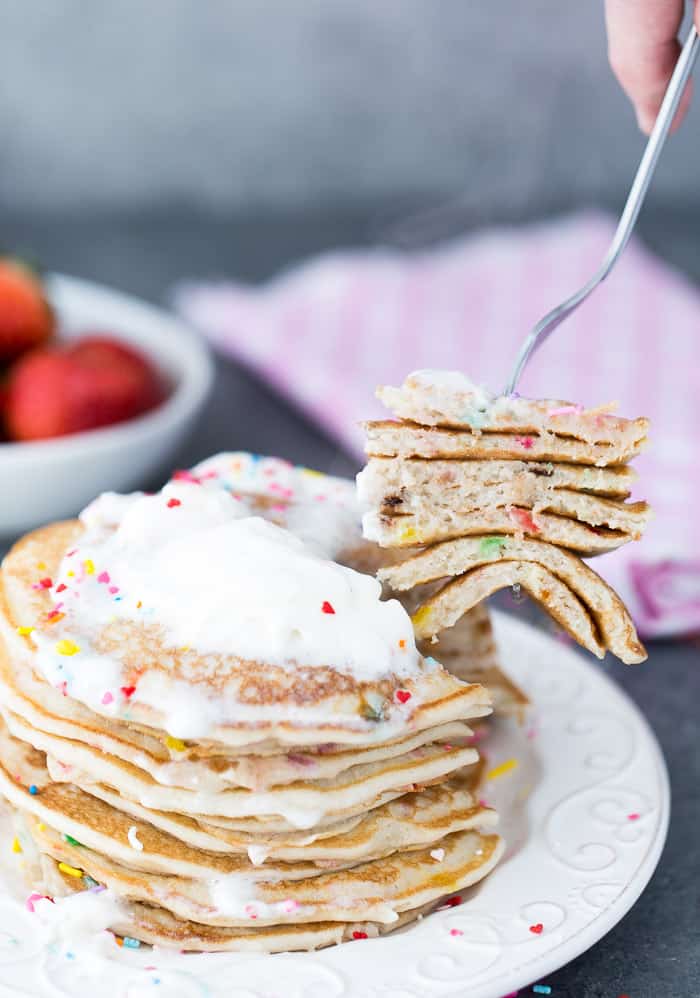 A stack of Funfetti pancakes on a white plate.