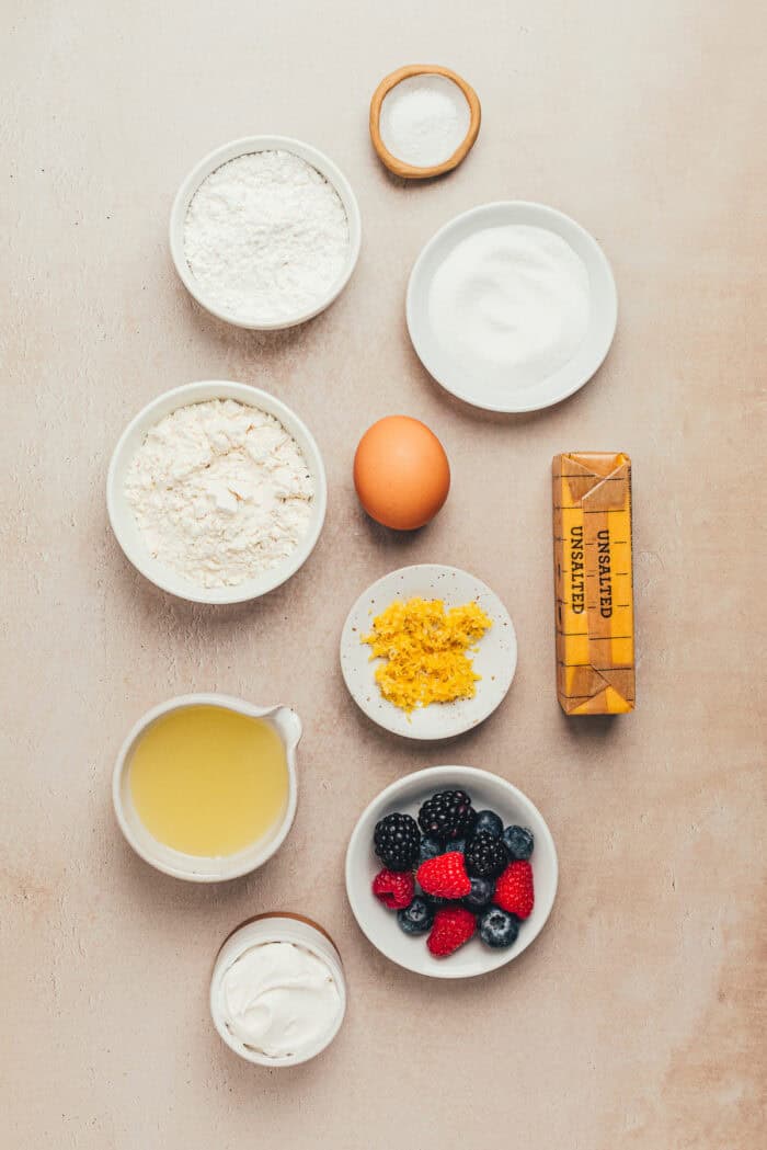 The ingredients needed to make a classic lemon tart in various bowls.