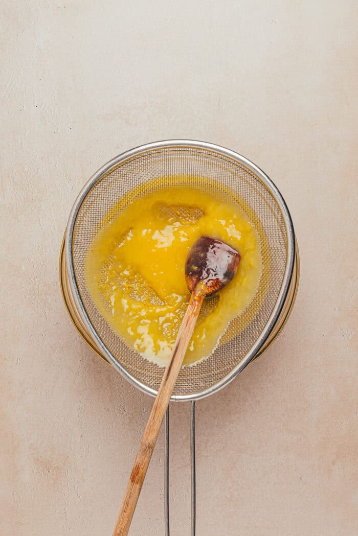 The custard being pushed through a sieve.