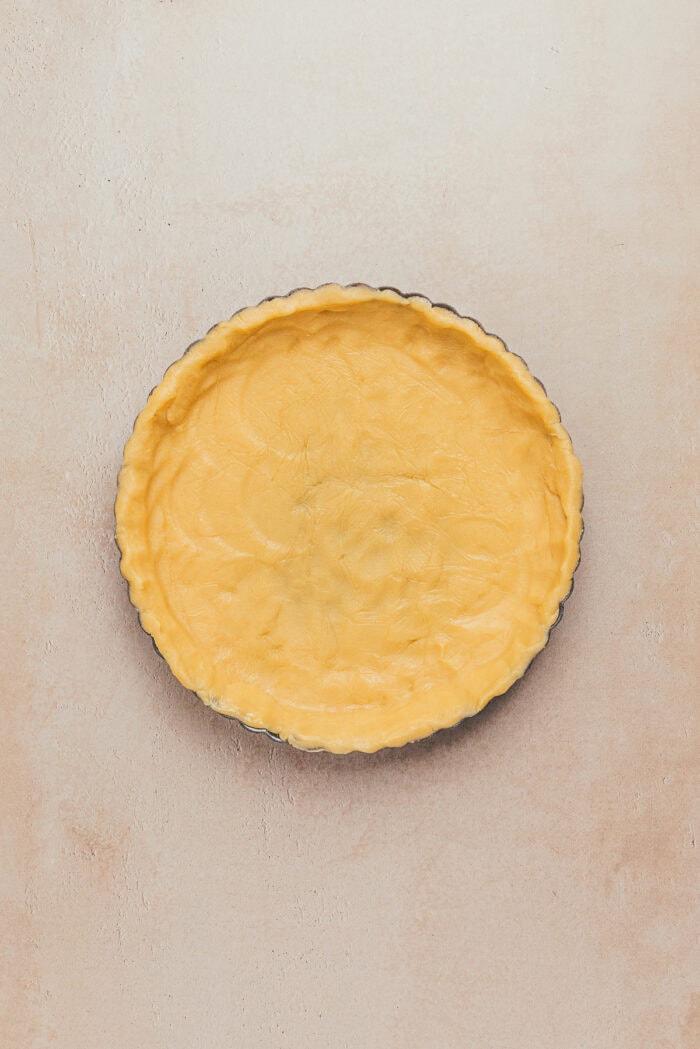 An unbaked shortbread tart crust in a tart pan.