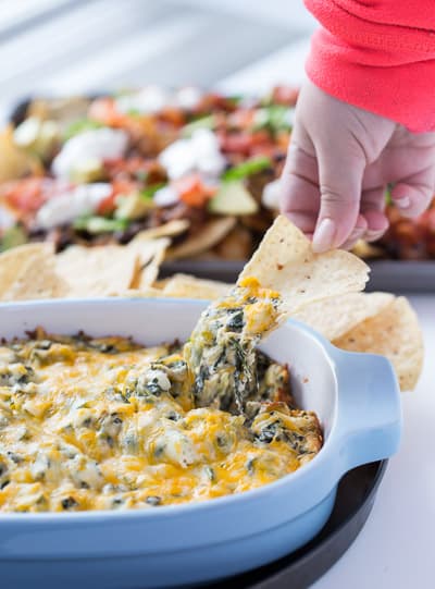 Chip dipped into cheesy spinach dip