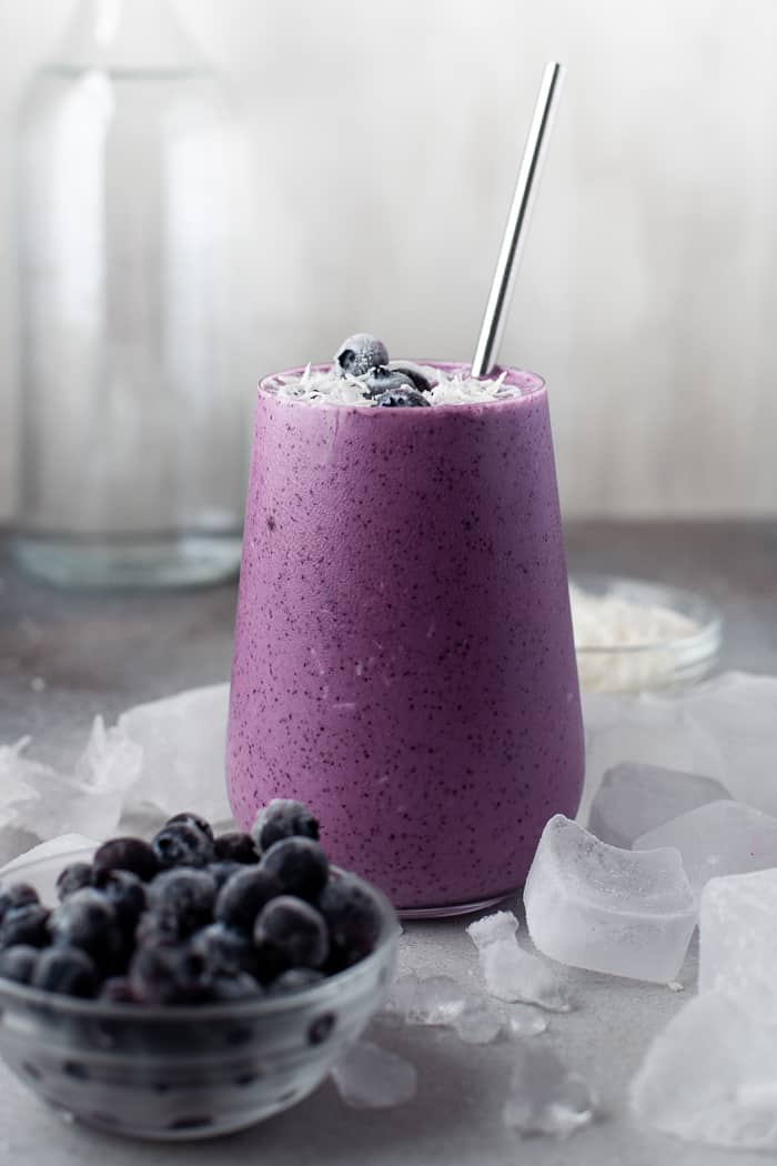 Healthy Blueberry Smoothie with blueberries and coconut around it. 