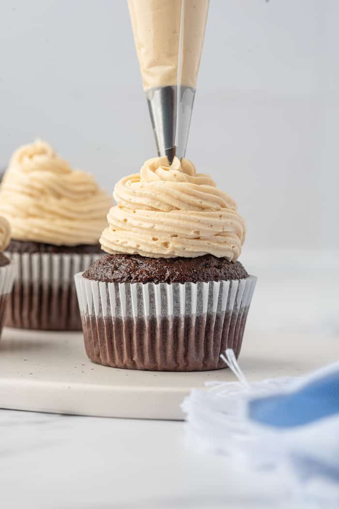 Chocolate Cupcakes being piped with Peanut Butter Buttercream