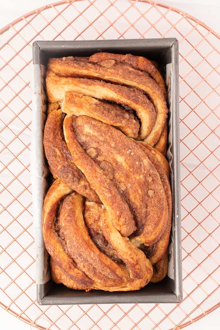 Cinnamon Swirl Bread cooling in a loaf pan. 