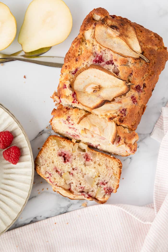 Pear and Raspberry Bread sliced on a marble background. 