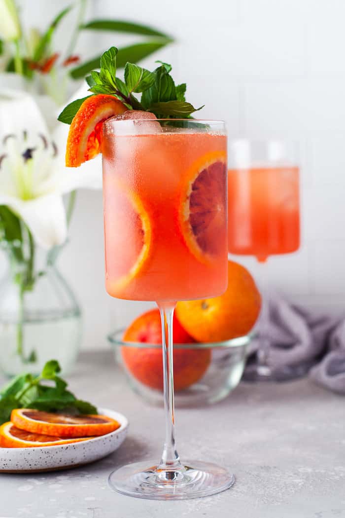 Blood orange cocktail in a glass with blood orange slices.