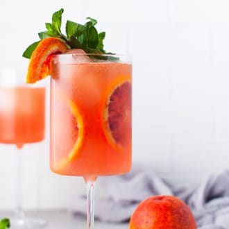 Blood orange cocktail in a glass with blood orange slices.