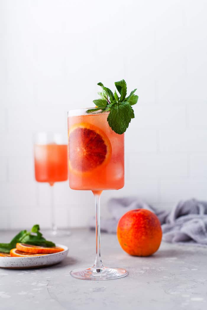 Blood orange cocktail in a glass with blood orange slices.