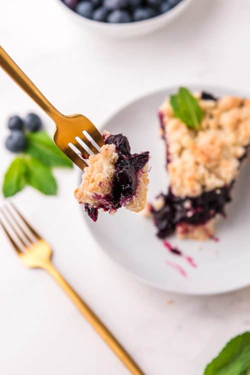 Blueberry crumb bars with a bite on a fork. 