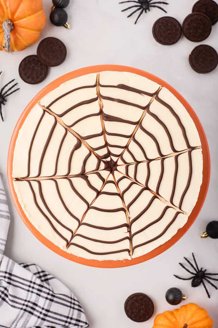 No-bake spider web cheesecake surrounded by Halloween decor. 