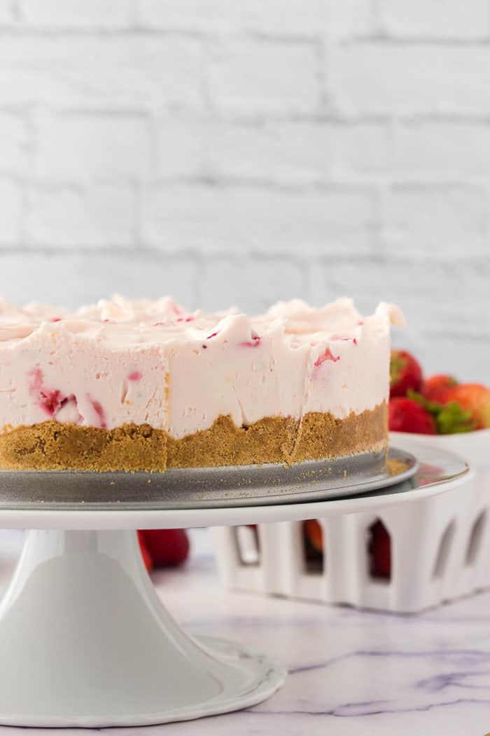 No bake strawberry cheesecake on a cake plate.
