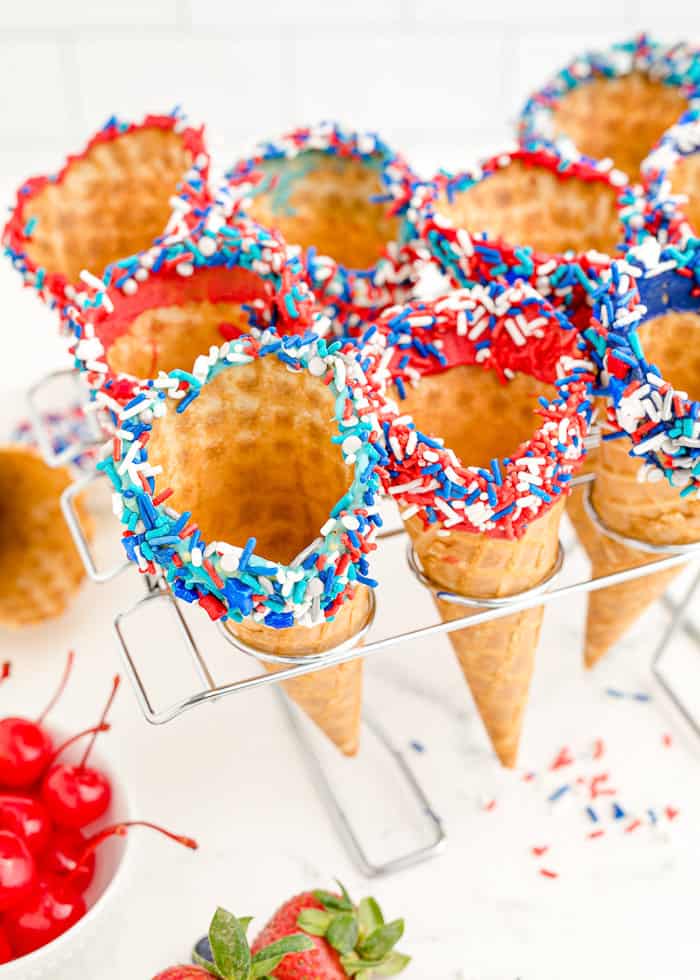 Waffle cones with sprinkles in a cone holder.