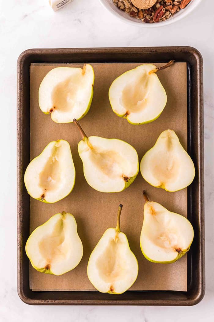 Pears cut in half on a baking sheet