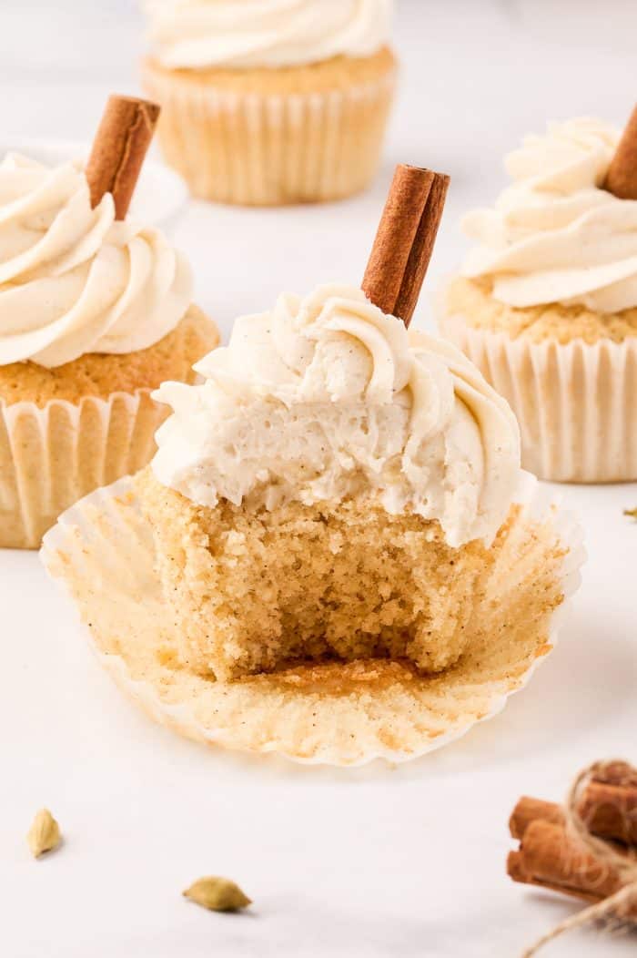 Chai cupcakes with a bite taken out of one of them.