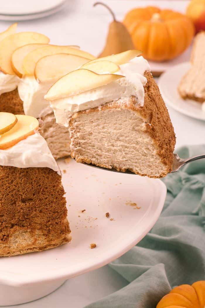 A slice of pumpkin spice angel food cake being removed from the cake.