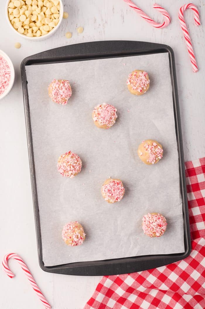 Unbaked peppermint white chocolate cookies on a cookie tray.