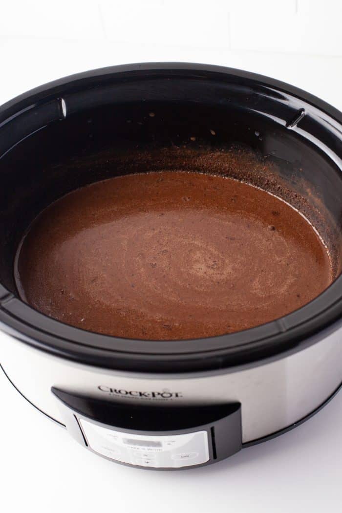 Add the remaining sugar, evaporated milk, chocolate chips, and vanilla. Mix and cover the slow cooker.
