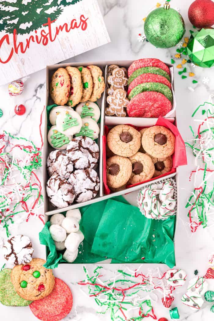 Placing cookies into a holiday cookie box.