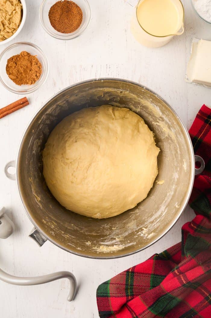 Eggnog cinnamon roll dough in a bowl.