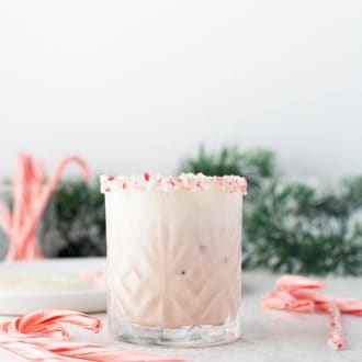 Peppermint White Russian in a glass with candy canes.