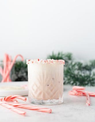 Peppermint White Russian in a glass with candy canes.